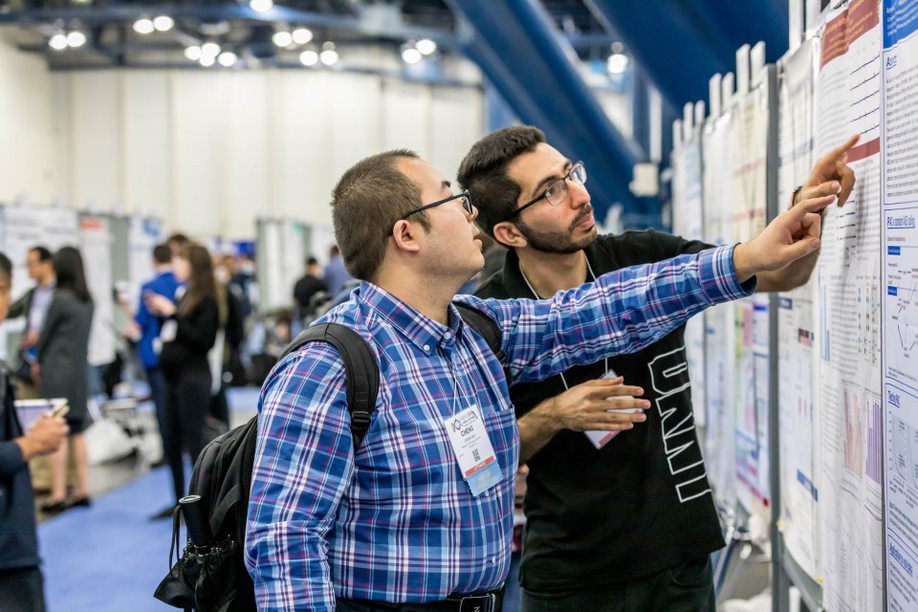 Meeting Attendees going over a Poster